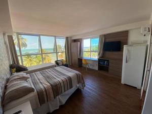 若昂佩索阿Flat vista Mar的一间卧室配有一张床、一台冰箱和窗户。