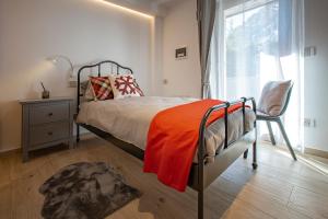 库马约尔Maison Altea的一间卧室配有一张带橙色毯子和窗户的床。