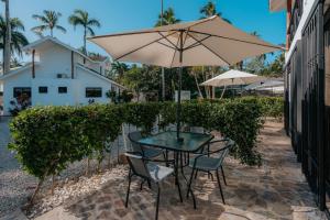 拉斯特拉纳斯Condo Hotel Playa Las Ballenas的庭院内桌椅和遮阳伞