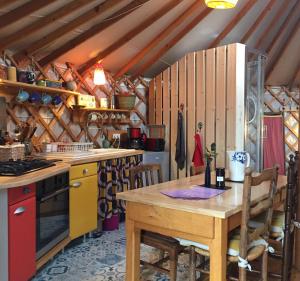 MoussagesLa Yourte的厨房配有木桌和炉灶。