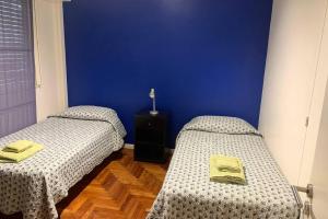 布宜诺斯艾利斯Best location in Caballito, Buenos Aires, 80 M2的蓝色墙壁客房的两张床