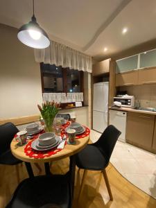 考斯赛力克Apartament Kryjówka pod Giewontem的一间带桌椅的厨房和一间带冰箱的厨房