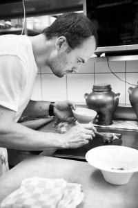布永拉费偌尼尔酒店的坐在厨房里的人在柜台上准备碗