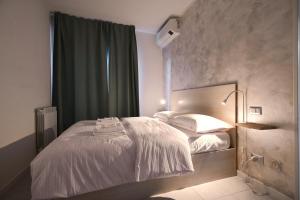 阿萨哥Apartment Forum III的卧室配有白色的床和绿色窗帘