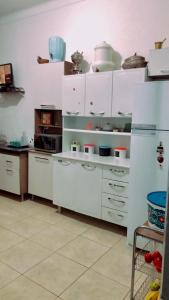 尤西德福拉Hostel Tropeiro de Minas的厨房配有白色橱柜和餐具