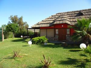 圣拉斐尔Cabañas Villa Lounge的庭院上茅草屋顶的房子