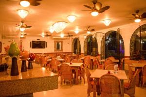 库库塔Hotel Chucarima的一间带桌椅和吊扇的餐厅