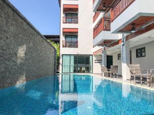 清迈Hotel De Sripoom -SHA Extra Plus的大楼前的游泳池