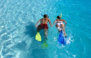 格雷斯湾Windsong on the Reef的两个人在水里玩耍