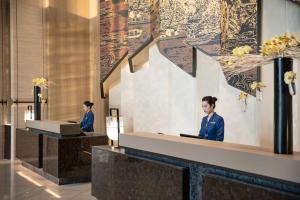 ShundeInterContinental Foshan DongPing的两人坐在大堂的前台