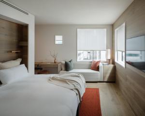奥克兰The Hotel Britomart的卧室配有白色的床和沙发