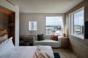 奥克兰The Hotel Britomart的一间卧室配有一张床、一张沙发和一个窗口