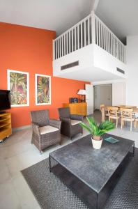 戛纳加纳克罗阿塞特酒店的客厅设有橙色墙壁和桌子