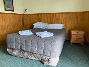 WoodvilleNew Central Hotel Woodville的一间卧室配有一张床,上面有两条毛巾