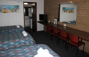 波特兰Portland Retro Motel的酒店客房带两张床,酒吧带椅子。