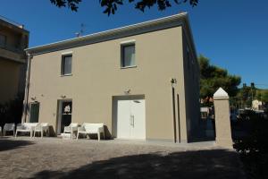 安科纳la casa in Ancona的一座带椅子和门的大型白色建筑
