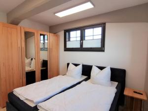 巴特Speicher Residenz Barth E3 App 1的一间卧室设有两张床和窗户。