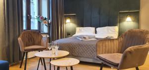 奥尔什丁DK Premium Warmińska Secesja的酒店客房,配有床和2把椅子和桌子