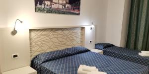 罗马日月旅馆的酒店客房,配有两张带蓝色床单的床