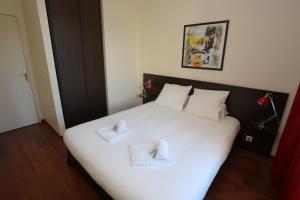 曼德琉-拉纳普勒奥苏耶芳酒吧及酒店的卧室配有白色的床和2条毛巾