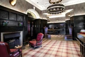 巴洛赫Loch Lomond Lodge的客厅设有壁炉和红椅