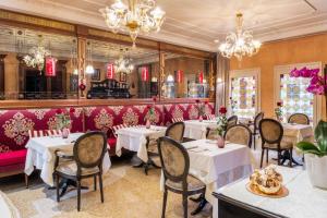 威尼斯摩里斯科酒店的餐厅设有白色的桌椅和吊灯。