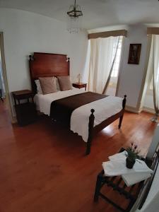 纳扎雷里巴马酒店的一间卧室设有一张大床,铺有木地板