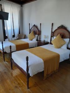 纳扎雷里巴马酒店的一间卧室配有两张带白色和黄色床单的床