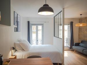 佩里格Apparts Limogeanne - Clim - Centre historique的卧室配有白色的床和蓝色的沙发