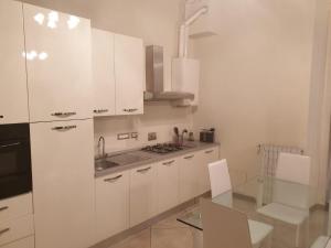 阿罗纳Arona Prestige Apartments的厨房配有白色橱柜和玻璃桌