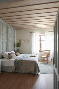DánszentmiklósHerba-ház的一间卧室设有一张带木制天花板的大床