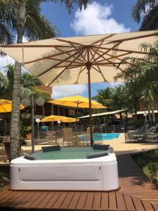 巴拉奈里奥-坎布里乌蓬塔多罗布酒店的游泳池配有遮阳伞和桌椅