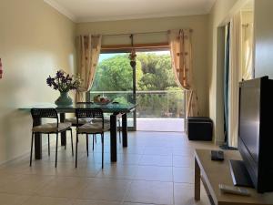 奥霍斯德古阿Delightful vacations apartment in Algarve的一间带桌椅和窗户的用餐室