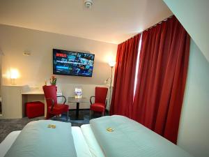 马克特雷德维茨斐克特高原迈斯特酒吧酒店的酒店客房,配有床和红色窗帘