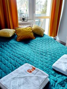翁格罗维茨Apartament Wągrowiec, Gabi - Remigiusz Kiszka的一间卧室配有蓝色的床、黄色枕头和窗户