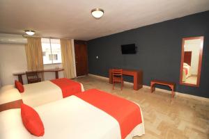 韦拉克鲁斯中央酒店 的酒店客房设有两张床、一张桌子和电视。