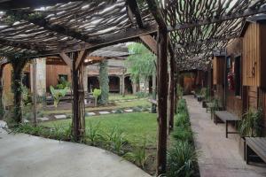 瓜达鲁佩镇Hotel Valle 13 Ruta del Vino的花园内带长椅的木制凉亭