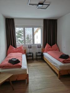 蓬特雷西纳Ferienwohnung Pontresina - Chesa Andrea - Gartensitzplatz的一间卧室设有两张床和两个窗户。