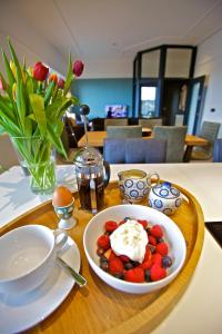 柯克沃尔Northlight Apartments - The Lookout的一张桌子,上面放着一盘草莓和奶油