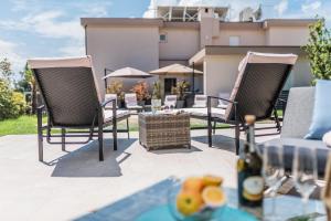 茨里克韦尼察Apartments Bego Spa & Wellness的天井配有两把椅子和一张桌子及一瓶葡萄酒