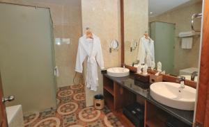 曼德勒Sunset Palace View Suites的浴室设有2个盥洗盆、淋浴和镜子。