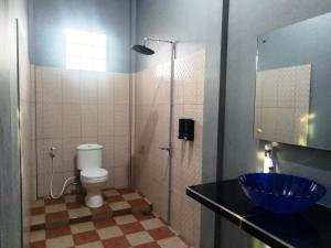 特尔纳特岛古妮亚民宿的浴室配有蓝色水槽和卫生间。