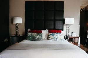 库鲁曼The Hedge Guesthouse的一间卧室配有一张大床和黑色床头板