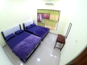 班图尔South City Homestay in Wirokerten的一间卧室配有一张紫色的床和一把椅子