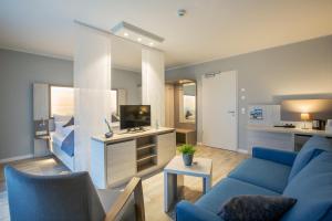 佩尔沃姆Nordsee Lodge的客厅配有蓝色的沙发和电视