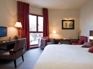 拉巴特拉巴特舍赫拉查德美居酒店的酒店客房,配有一张床、一张桌子和椅子