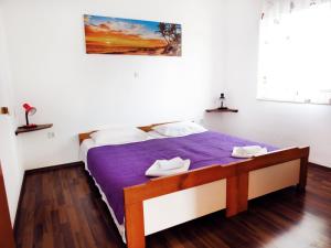 苏佩塔尔Apartment Jadro的一间卧室配有一张带紫色棉被的床