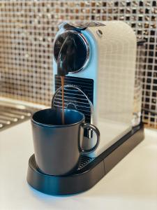 拉脱维亚Villa Gaida的咖啡壶把咖啡倒在柜台的杯子里