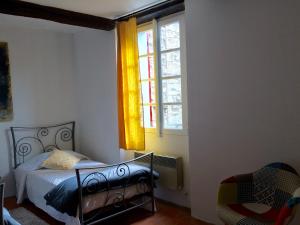 萨路特德沃克吕兹LA MAISON D’ALICE的一间卧室设有一张床和一个窗口