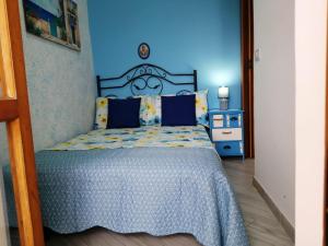 奥特朗托Bilocale Punta Rosa - Fronte Spiaggia的一间卧室配有一张蓝色墙壁的床
